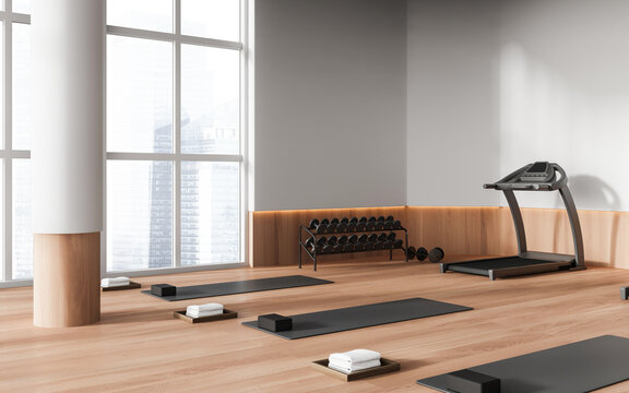 Stylish wooden gym class interior with treadmill and yoga mat, panoramic window