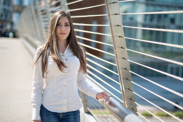 Portrait of a young woman near a bridge