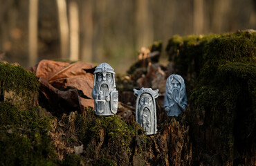 vintage ritual stone idols on tree stump close up, abstract natural forest background. old gods...