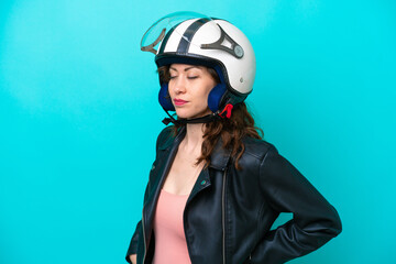 Young caucasian woman with a motorcycle helmet isolated on blue background suffering from backache for having made an effort