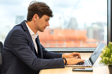 Young businessman work relaxing using technology laptop computer on table at office.Young creative man working and typing on keyboard, technology, online, email, job, project on workplace