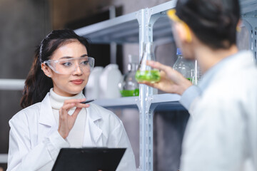 Pharmaceutical factory woman worker in protective clothing operating production line in sterile environment, scientist with glasses and gloves checking hemp plants in a marijuana farm