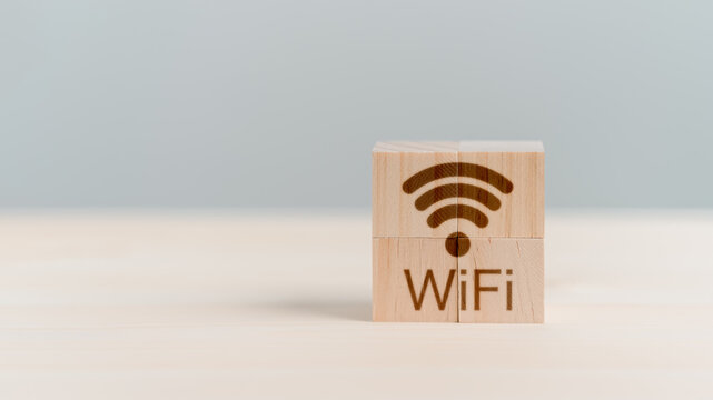 Wifi icon on wooden cube block for service in the cafe. Business communication social network with wi-fi, Wireless network and connection technology concept.