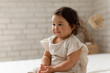 Fototapeta premium Portrait Of Cute Asian Baby Girl Sitting Looking Aside Indoor