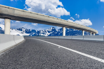 Obraz premium Asphalt road and bridge with snow mountain background