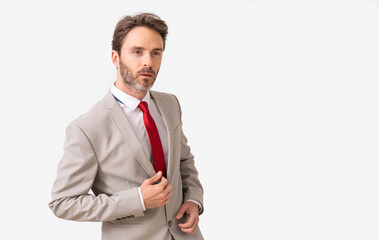 Handsome male model posing wearing a silver suit and a red tie.