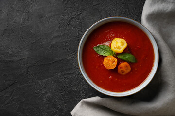 Gazpacho soup with tomato and ingredients on black background