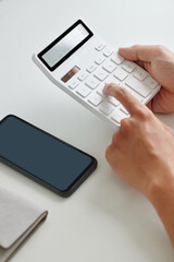 Hands of entrepreneur calculating profit of new project