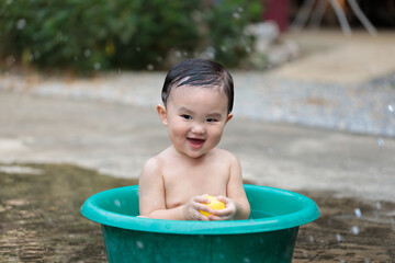 Child is playing plastic ball and water in summer.