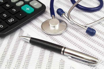Documents with numbers, calculator and stethoscope with pen.	