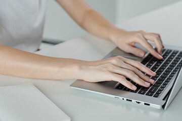 Fototapeta na wymiar Hands of young woman coding on laptop at minimalistic desk