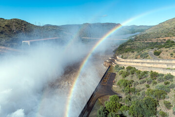 Bridge below Gariep Dam visible behind double rainbow