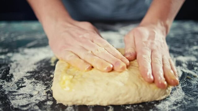 Close-up of a chef's hands shaping dough into a pizza pan. Cooking a delicious dinner with pastries at home. High quality 4k footage