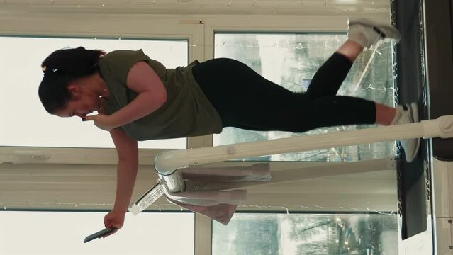 Chubby woman doing selfie on phone while training on treadmill. Vertical video