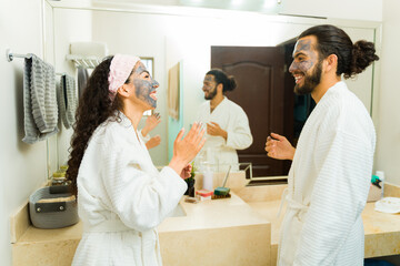 Relaxed couple putting on mud masks