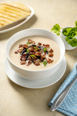 Closeup mushroom creamy soup with bakon garnish in a bowl. 
