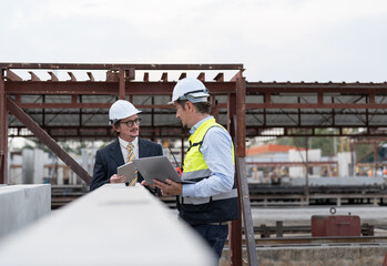 Businessman and male engineer discussing the quality of steel bar in concrete for making precast concrete wall at construction site.