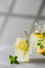 Homemade lemonade with fresh lemon slices and mint leaves in a glass. A summer refreshing drink.