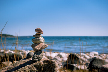 Stones stacked in harmony on beach for meditation, zen, tranquility, and work-life balance concept