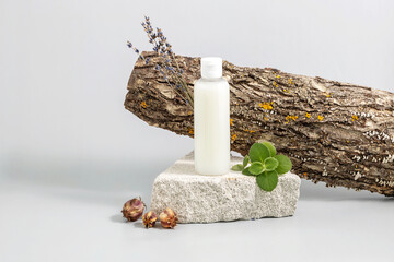 cosmetics container on the podium made of stone, tree bark, lavender twigs and mint leaves on a...