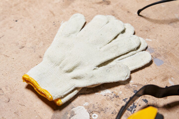 Fototapeta na wymiar new white cotton gloves for worker lie on a wooden surface