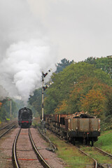 Fototapeta na wymiar A Vintage Steam Train Engine Passing Freight Wagons.