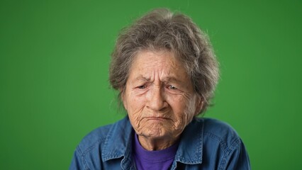 Tired depressed elderly mature toothless old woman 80s with migraine headache posing isolated on green screen background studio. Closeup people lifestyle concept. Put hands face