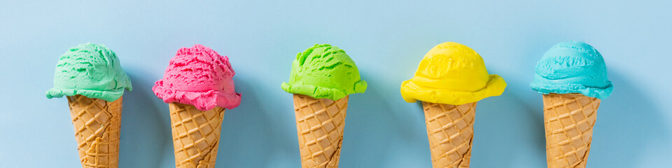 Colorful ice cream scoops in cones, bright blue background