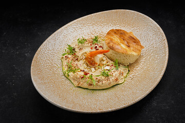 Hummus with shrimp, peanuts, chickpeas and a bun, on a plate