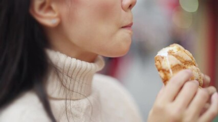 4K Happy Asian woman eating Japanese sweet bread during travel at Sensoji Temple in Asakusa, Tokyo, Japan. Attractive girl enjoy and fun urban outdoor lifestyle travel city street on holiday vacation.
