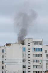 Burning roof of a residential high-rise building, clouds of smoke from the fire. Smoke fire building roof. Selective focus