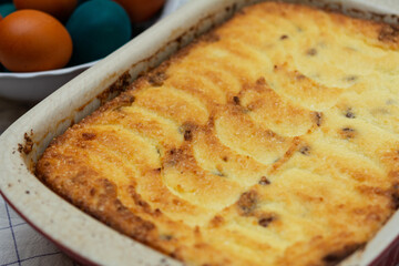 Easter cottage cheese casserole. Homemade pastry, freshly baked cottage cheese casserole and eggs on background. Selective focus, shallow depth of field