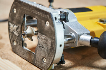 close-up of a decorative woodworking router bit mounted on a hand router