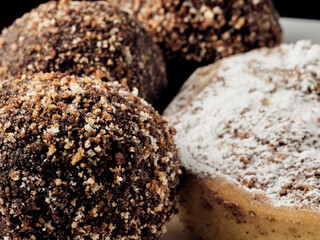 Vegan sugar-free cocoa truffles and cake on a slate plate. dark background.
