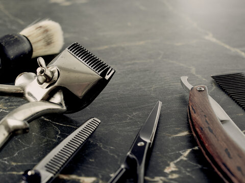 On a grey marble surface are old barber tools