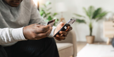 Man hand holding credit card and using mobile phone at home, Businessman or entrepreneur working, Online shopping, e-commerce, internet banking, spending money, working from home concept