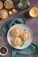 Tartlets filled with canned fish, eggs and mayonnaise on a plate top and vertical view