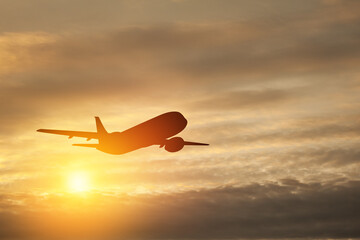 Fototapeta na wymiar Airplane taking off at the sunset sky.