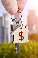 The keys to the new apartment in the hand of a man against the backdrop of urban development