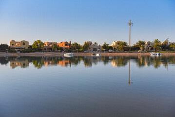 Fototapeta na wymiar Häuser im nubischen Stil in El Gouna, Ägypten,, die sich im Wasser der Lagune spiegeln