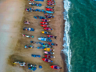 Fototapeta na wymiar Aerial shot from a drone of a group of local fishing boats at Jomtien Beach, Pattaya, Thailand.