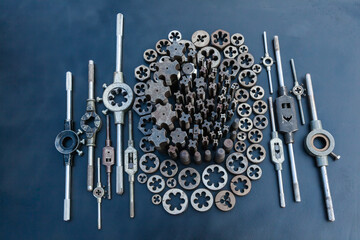 Taps, dies and wrenches for taps and dies on a black background. Manual tool for threading.