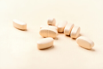 Vitamin C tablets on bright paper background. Soft focus. Close up. Copy space. 
