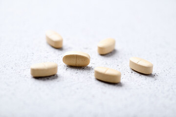  Vitamin C tablets on bright paper background. Soft focus. Close up. Copy space.