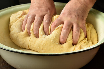 Male hands are preparing the dough.