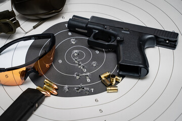 Shooting at a target in a shooting range.  Target with bullet holes in the center pistol,...