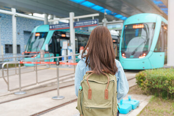 Obraz premium woman traveler visiting in Taiwan, happy Tourist traveling in Light Rail System near Tamsui District Taipei city, landmark and popular attractions. Asia Travel, vacation and Trip concept
