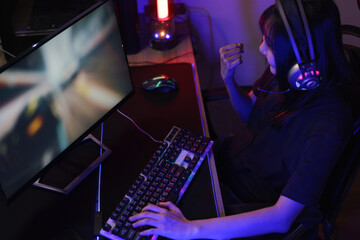 Female cyber hacker gamer in headphones making win gesture after hacking programming system success