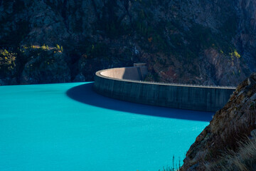 Dam of the Lake Place Moulin, an artificial glacial lake with turquoise water in the italian Alps,  on the border with Switzerland