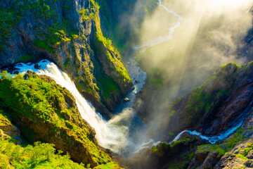 Naklejka na ściany i meble Amazing sunbeams passing through the mist created by the Voringfossen waterfalls, Norway